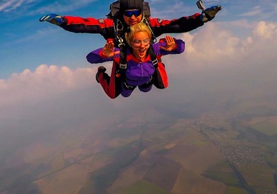 Щаслива людина у вільному падінні під час стрибка з парашутом в тандемі з інструктором