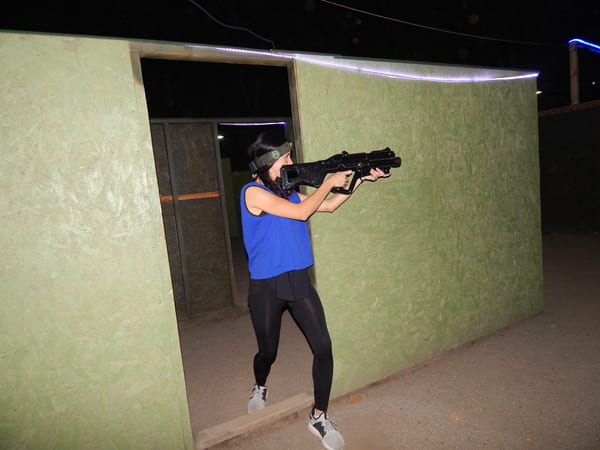 Гравець стріляє під час гри у лазертаг на майданчику