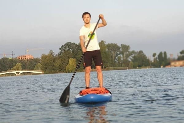 SUP-бординг в Івано-Франківську — чоловік веслує стоячи на дошці посеред міського озера