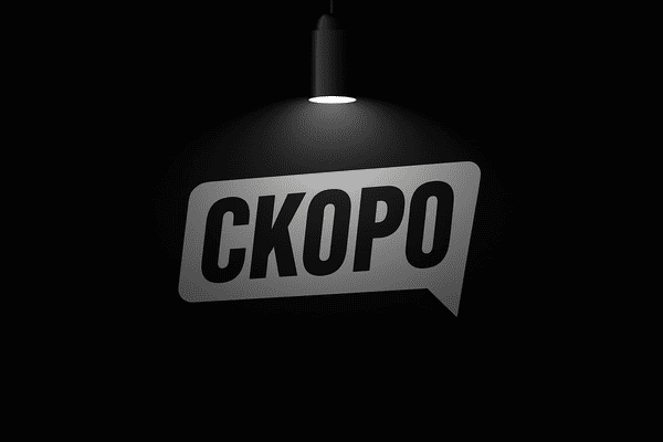 Надпис "Скоро" на чорному фоні під чорною лампою