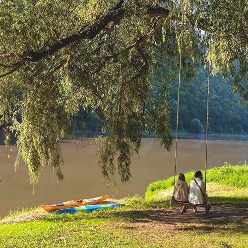 Пара на гойдалці біля Дністра з каяками та видом на Дністровський каньйон