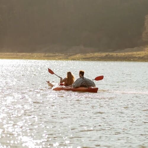 Пара у каяку пливе по Дністру восени, вигляд ззаду